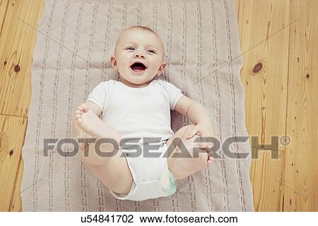Portrait of smiling baby boy lying on blanket View Large Photo Image Stock Image - Portrait of smiling baby boy lying on blanket. Fotosearch