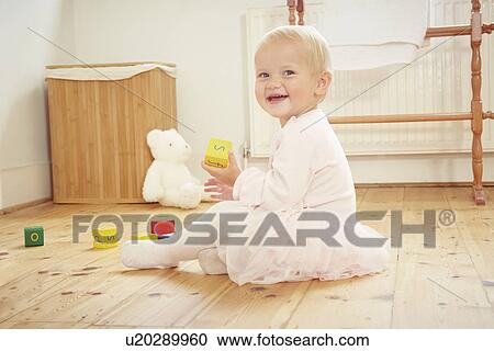 Portrait of smiling baby girl playing on floor with building blocks View Large Photo Image Stock Image - Portrait of smiling baby girl playing on floor with building blocks. Fotosearch