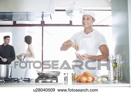 Portrait of smiling male chef mixing with mortar and pestle in commercial kitchen View Large Photo Image Stock Photo - Portrait of smiling male chef mixing with mortar and pestle in commercial kitchen. Fotosearch