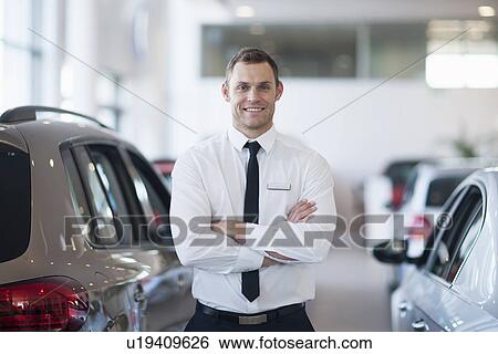 Portrait of smiling salesman in car dealership View Large Photo Image Stock Photograph - Portrait of smiling salesman in car dealership. Fotosearch