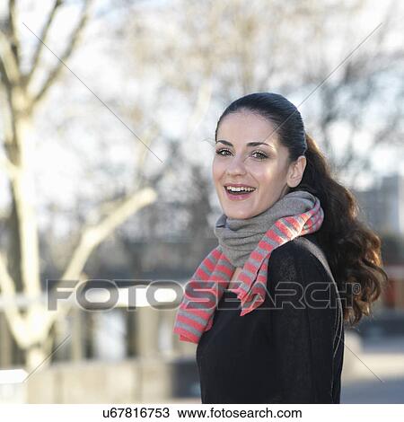 Portrait of smiling young woman in city View Large Photo Image Stock Image - Portrait of smiling young woman in city. Fotosearch