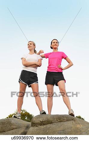 Portrait of two proud female runners on top of rock formation View Large Photo Image Stock Image - Portrait of two proud female runners on top of rock formation. Fotosearch