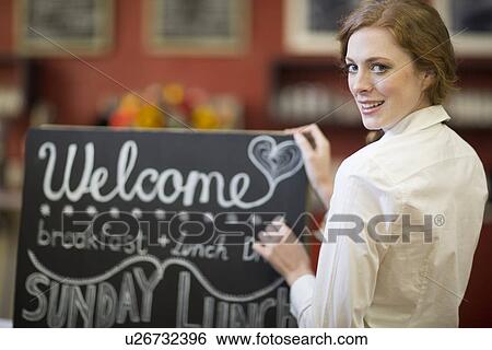 Portrait of waitress chalking menu on blackboard in restaurant View Large Photo Image Stock Photograph - Portrait of waitress chalking menu on blackboard in restaurant. Fotosearch