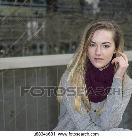 Stock Image - Portrait of young woman by riverside. Fotosearch