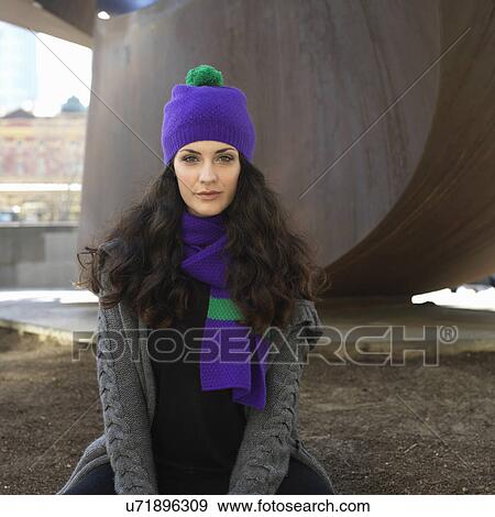 Stock Photo - Portrait of young woman in knit hat and scarf at city underpass. Fotosearch
