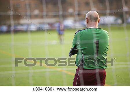 Stock Photo - Rearview of goalie at football game. Fotosearch