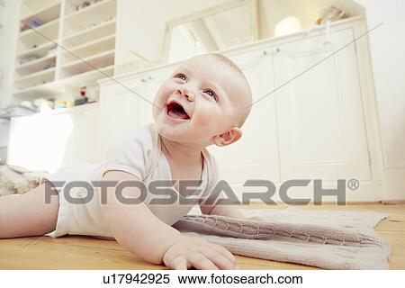 Smiling baby boy crawling on sitting room floor View Large Photo Image Stock Photography - Smiling baby boy crawling on sitting room floor. Fotosearch