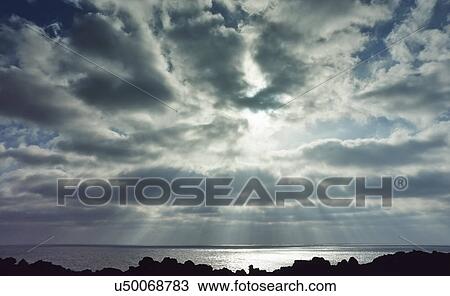 Stock Image - Stormy sky and silhouetted rocks, Lanzarote, Canary Islands, Spain. Fotosearch