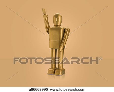 Stock Photography - Studio shot of gold robot with arm raised. Fotosearch