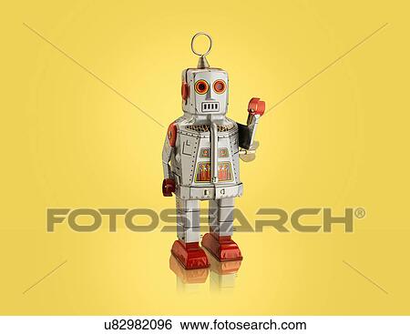 Stock Photograph - Studio shot of silver robot with arm raised. Fotosearch