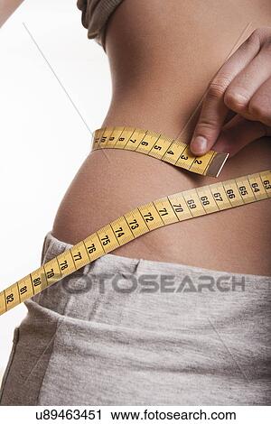 Stock Image - Tape measure around waist. Fotosearch