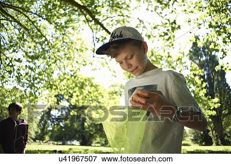 Stock Photo - Teenage boy holding fishing net. Fotosearch