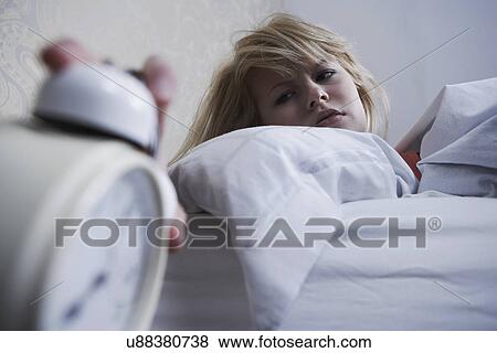 Teenage girl turning off alarm clock View Large Photo Image Stock Photo - Teenage girl turning off alarm clock. Fotosearch