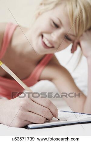 Stock Photo - Teenage girl writing in notebook. Fotosearch