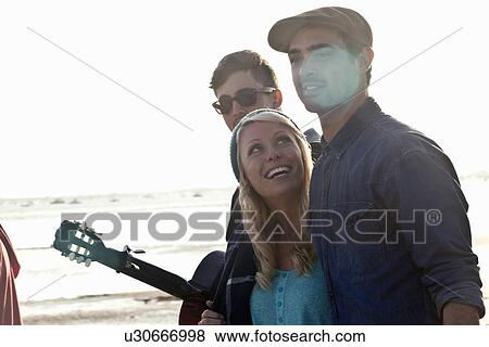 Three adult friends with acoustic guitar on Bournemouth beach, Dorset, UK View Large Photo Image Stock Photo - Three adult friends with acoustic guitar on Bournemouth beach, Dorset, UK. Fotosearch
