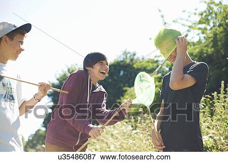 Stock Photo - Three boys playing with fishing nets. Fotosearch