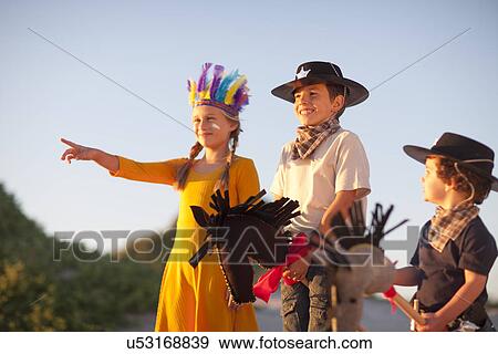 Three children dressed as native american and cowboys pointing from sand dunes View Large Photo Image Stock Photo - Three children dressed as native american and cowboys pointing from sand dunes. Fotosearch