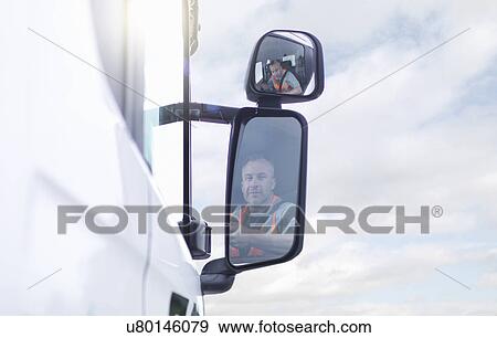 Stock Photo - Truck driver reflected in wing mirror. Fotosearch