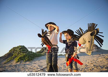 Two brothers dressed as cowboys shading eyes with hands View Large Photo Image Stock Photo - Two brothers dressed as cowboys shading eyes with hands. Fotosearch