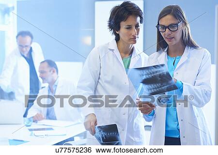 Two doctors looking at x-rays View Large Photo Image Stock Photograph - Two doctors looking at x-rays. Fotosearch