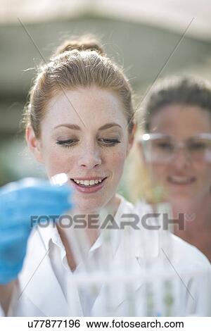 Stock Photograph - Two female scientists monitoring plant samples in test tubes. Fotosearch