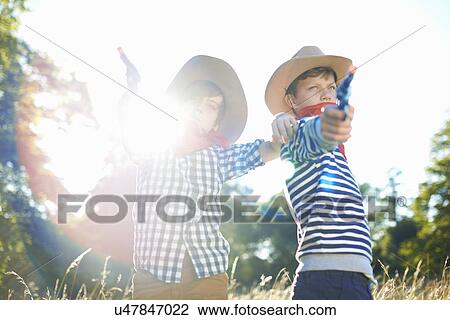 Two young boys dressed as cowboys, holding toy guns View Large Photo Image Stock Image - Two young boys dressed as cowboys, holding toy guns. Fotosearch