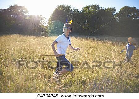 Two young boys playing in a field View Large Photo Image Stock Photo - Two young boys playing in a field. Fotosearch