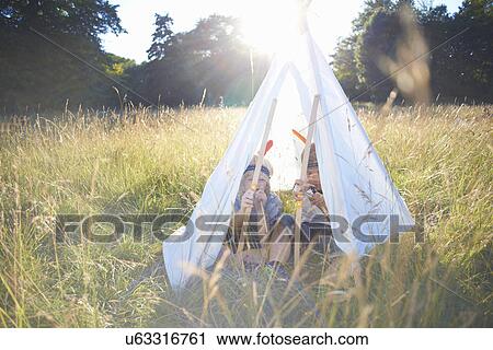 Two young boys sitting inside a teepee View Large Photo Image Stock Image - Two young boys sitting inside a teepee. Fotosearch