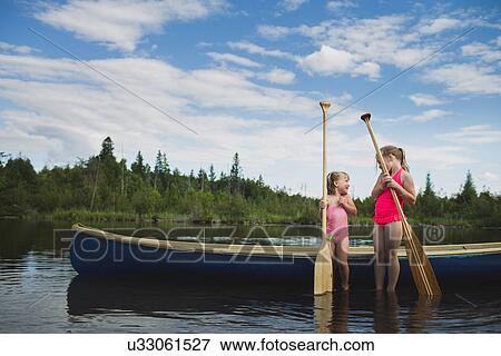 Two young sisters chatting next to canoe on Indian river, Ontario, Canada View Large Photo Image Stock Photo - Two young sisters chatting next to canoe on Indian river, Ontario, Canada. Fotosearch