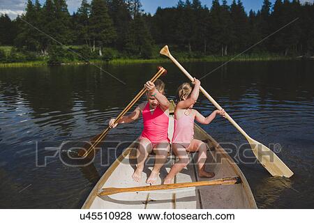 Two young sisters rowing in canoe on Indian river, Ontario, Canada View Large Photo Image Stock Photo - Two young sisters rowing in canoe on Indian river, Ontario, Canada. Fotosearch