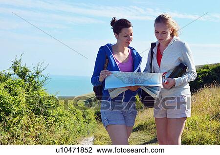 Two young women on coastal path with map View Large Photo Image Stock Image - Two young women on coastal path with map. Fotosearch