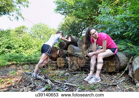 Two young women runners taking a break in forest View Large Photo Image Stock Image - Two young women runners taking a break in forest. Fotosearch