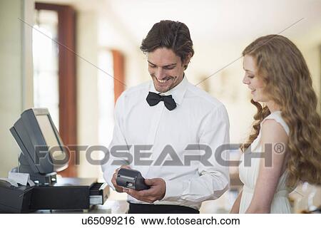 Waiter and female customer using credit card machine in restaurant View Large Photo Image Stock Photograph - Waiter and female customer using credit card machine in restaurant. Fotosearch