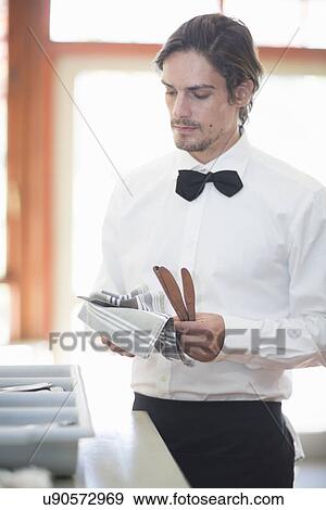 Waiter polishing cutlery in restaurant View Large Photo Image Stock Photo - Waiter polishing cutlery in restaurant. Fotosearch