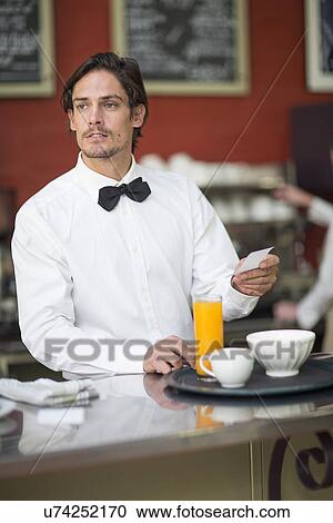 Waiter preparing drinks order at bar in restaurant View Large Photo Image Stock Image - Waiter preparing drinks order at bar in restaurant. Fotosearch