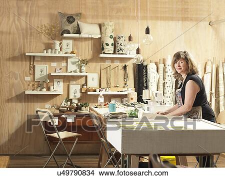Picture - Woman at work table in hand-printing textile workshop. Fotosearch