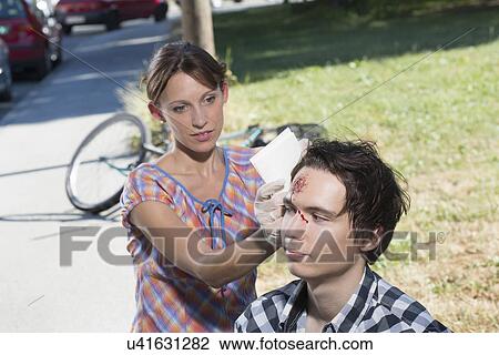 Woman cleaning man with bleeding forehead View Large Photo Image Stock Image - Woman cleaning man with bleeding forehead. Fotosearch
