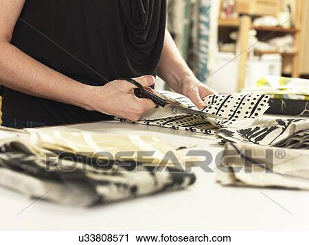 Woman cutting fabric on work table in hand-printed textile workshop View Large Photo Image Stock Image - Woman cutting fabric on work table in hand-printed textile workshop. Fotosearch
