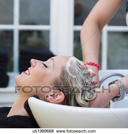 Stock Photo - Woman having hair shampooed in salon. Fotosearch