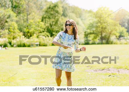 Stock Image - Woman playing disc game in the park. Fotosearch
