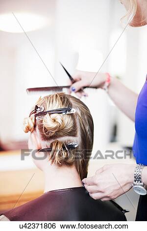 Stock Photograph - Woman with hair clips in hair in salon. Fotosearch