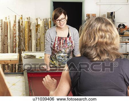Stock Photograph - Women hand-printing textile in workshop. Fotosearch