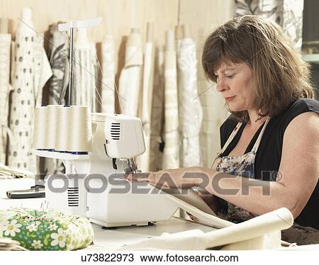 Stock Image - Women sewing in hand-printing textile workshop. Fotosearch