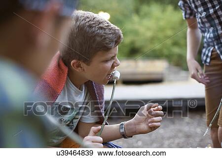 Young boy eating toasted marshmallow from stick View Large Photo Image Stock Photo - Young boy eating toasted marshmallow from stick. Fotosearch