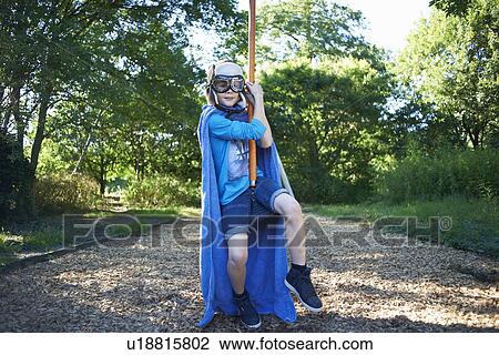 Stock Image - Young boy in fancy dress, on zip wire. Fotosearch