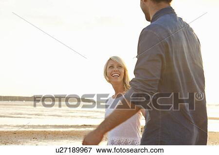 Stock Photo - Young couple enjoying beach. Fotosearch