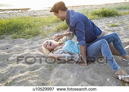 Young couple fooling around on Bournemouth beach, Dorset, UK View Large Photo Image Stock Photo - Young couple fooling around on Bournemouth beach, Dorset, UK. Fotosearch