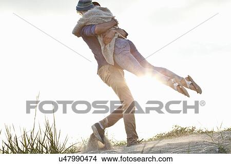 Picture - Young couple hugging on Bournemouth beach, Dorset, UK. Fotosearch