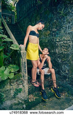 Stock Photo - Young couple on steps, looking at each other. Fotosearch