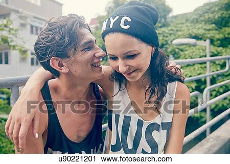 Young couple, smiling with arms around each other View Large Photo Image Stock Image - Young couple, smiling with arms around each other. Fotosearch